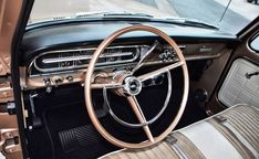 the interior of an old fashioned car with wood trim and chrome steering wheel rims