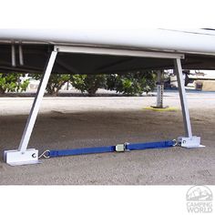 a white surfboard sitting on top of a sandy beach next to a metal pole