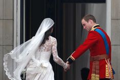 the bride and groom hold hands as they leave buckingham palace