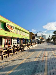 the boardwalk is lined with benches and tables