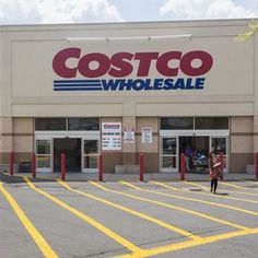 a costco whole sale store with people walking in front