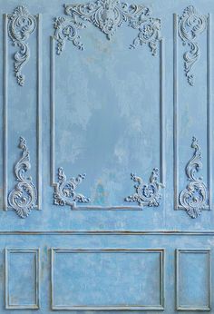 a blue door with ornate carvings on the front and side panels, painted light blue