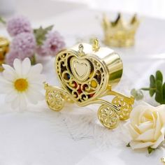 there is a gold carriage with hearts on it and white flowers around the carton