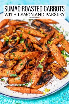 grilled carrots with lemon and parsley on a white plate next to a blue background