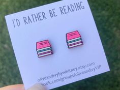 a pair of pink and blue book earrings