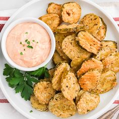 a white plate topped with fried potatoes and dipping sauce