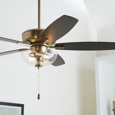 a ceiling fan with two light bulbs and a glass ball on the bottom of it