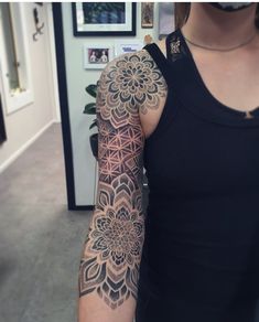 a woman's arm with a flower tattoo on the left side of her arm