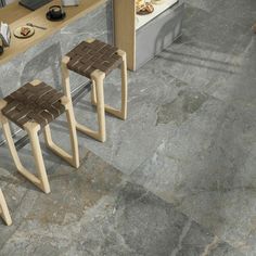 two wooden stools sitting next to a counter