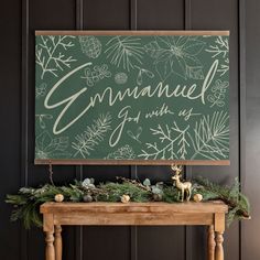 a christmas mantle with greenery and a sign that says gnannuel joy