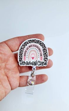 a person holding a badge with the words behanval crew on it in front of a white background