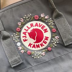 a gray bag with a red and white logo on it