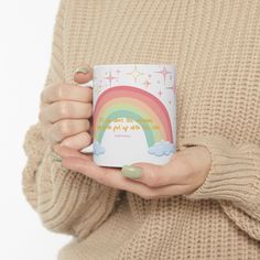 a woman is holding a coffee mug with a rainbow on it and the words, i love you so much