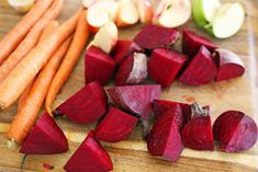 carrots and beets are on a cutting board