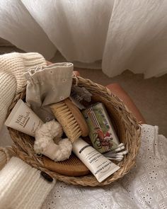 a basket filled with personal care items on top of a bed