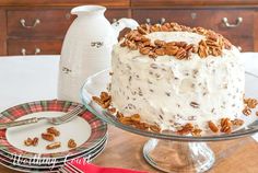 there is a cake on the table with pecans around it