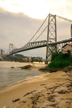 a large bridge spanning over a river next to a beach