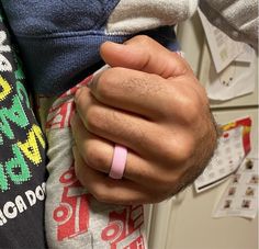 a close up of a person wearing a pink band around their wrist with one hand on the other