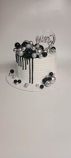 a white cake with black and silver decorations