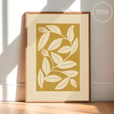 an image of a framed art print with leaves on it in the corner of a room