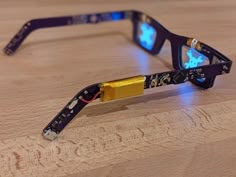 a pair of glasses that are sitting on top of a wooden table with blue light blocking them