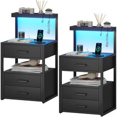 two black nightstands with blue lights and remote controls on each side, one has an alarm clock