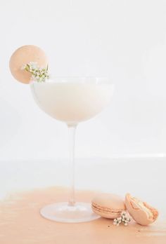 a glass filled with white liquid next to an egg