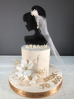 a wedding cake with white flowers and a veil on top