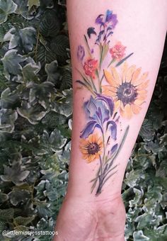 a woman's arm with flowers painted on it