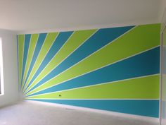 an empty room with blue and green stripes painted on the wall