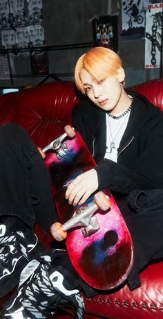 a person sitting on a couch holding a skateboard