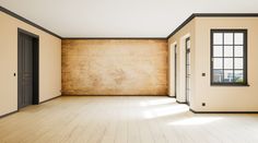 an empty room with wooden floors and two doors on one side, looking out onto the street