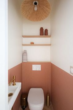 a toilet and sink in a small room with pink wall paper on the walls above it