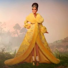 a barbie doll wearing a yellow dress and fur coat