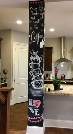 a tall chalkboard sign with coffee and love written on it in a kitchen area