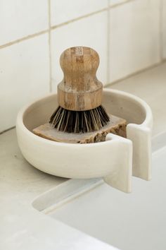 a brush is sitting in a bowl on the counter