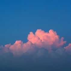 a plane flying in the sky with pink clouds behind it and blue sky above them