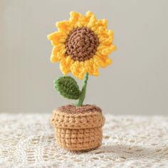 a crocheted sunflower sitting on top of a small pot filled with dirt