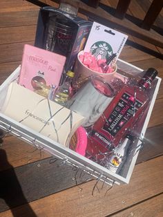 a container filled with lots of different items on top of a wooden floor next to a table