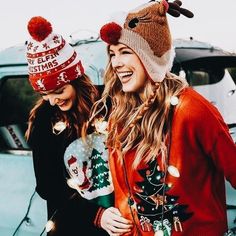 two women wearing ugly christmas sweaters and hats