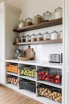 a kitchen with open shelves filled with fruits and veggies on top of it