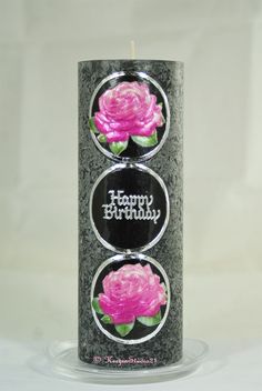 a birthday candle with two pink roses on the front and one in the back that says happy birthday