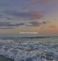 an ocean with waves crashing on it and the words grace over grudges above them