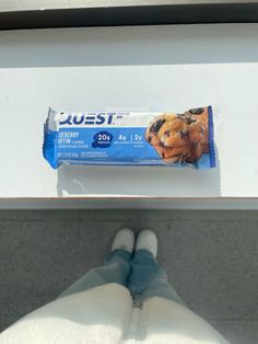 a person standing next to a bar of food on top of a white countertop