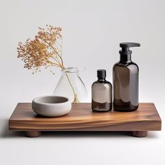 a wooden tray with two bottles and a bowl next to each other on top of it