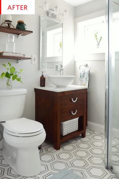 a white toilet sitting next to a sink in a bathroom under a mirror and shelves