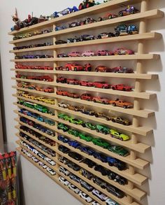 toy cars are lined up on the wall next to each other in this playroom