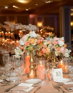 an elegant table setting with candles and flowers in vases on the center, along with place settings