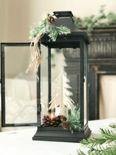 a lantern is decorated with pine cones and greenery