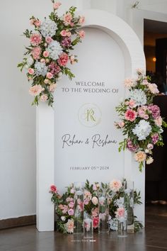 the welcome sign is decorated with flowers and greenery as well as candles for each guest